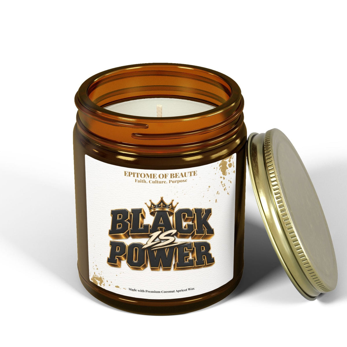An amber glass jar candle with a white label reading 'BLACK vs POWER' and 'EPTONE OF BEAUTe' above it, shown with the gold-toned metal lid leaning against it on a white studio background.
