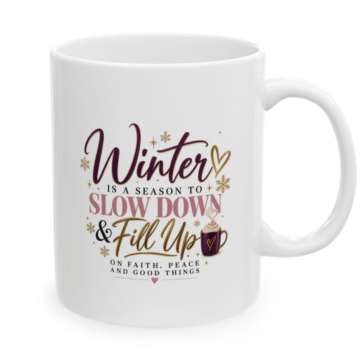A white ceramic mug with a winter-themed printed quote that reads 'Winter is a season to slow down & fill up' and 'On faith, peace, and good things' in dark brown and pink lettering with gold accents.