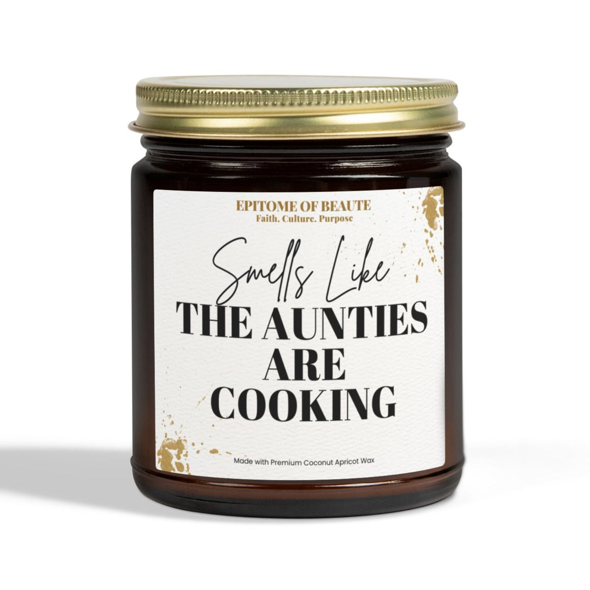 A dark amber glass jar candle with a gold metal lid and a white label that reads 'Smells Like THE AUNTIES ARE COOKING' on a clean white background.