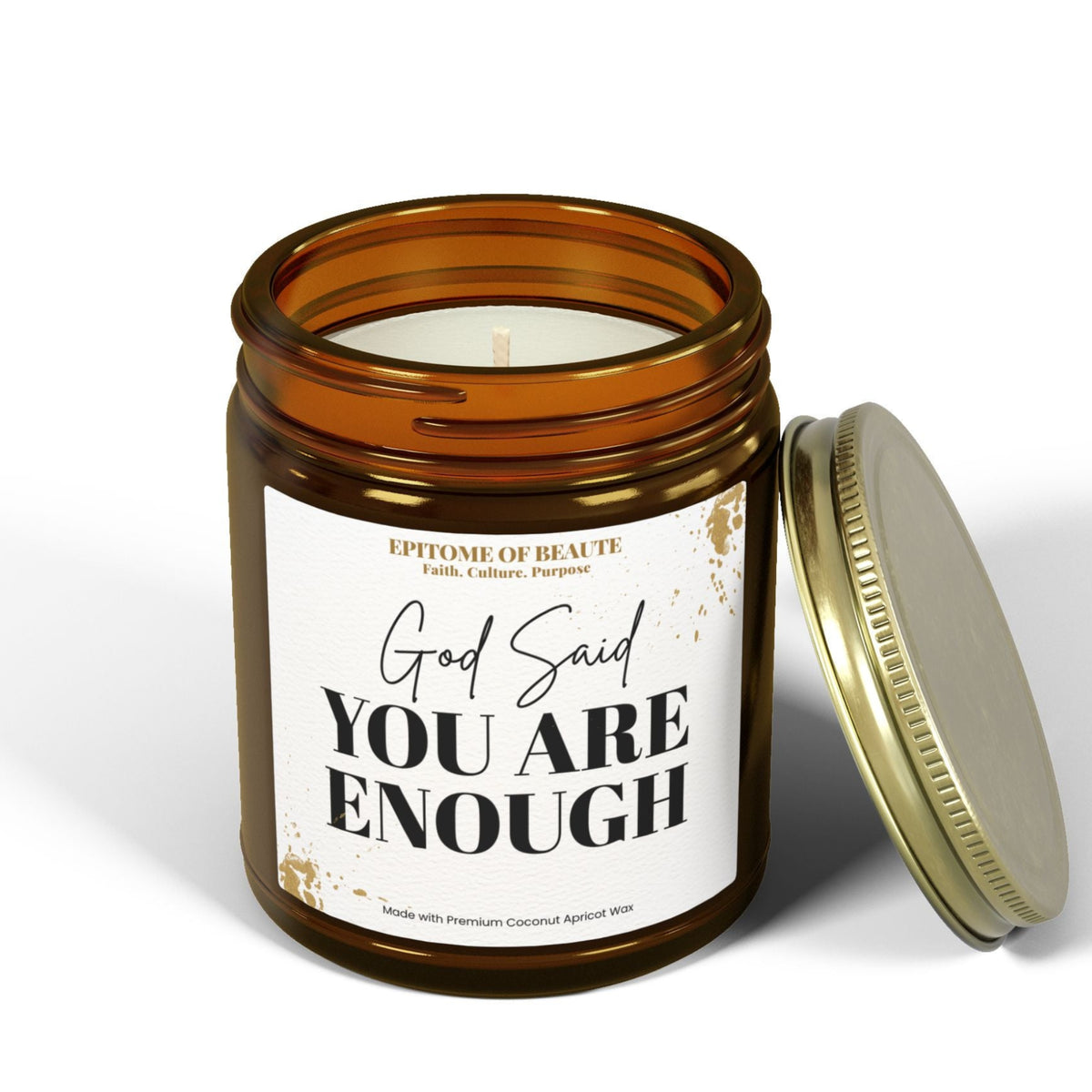 An amber glass jar candle with a white label reading 'Small Town Big Heart' and 'Charleston, Oklahoma,' shown with its gold-toned metal lid leaning against it on a white studio background.