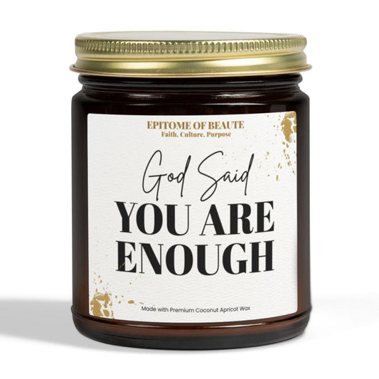 A dark amber glass jar candle with a gold metal lid and a white label that reads 'God Said YOU ARE ENOUGH' in black text, shown on a clean white background.